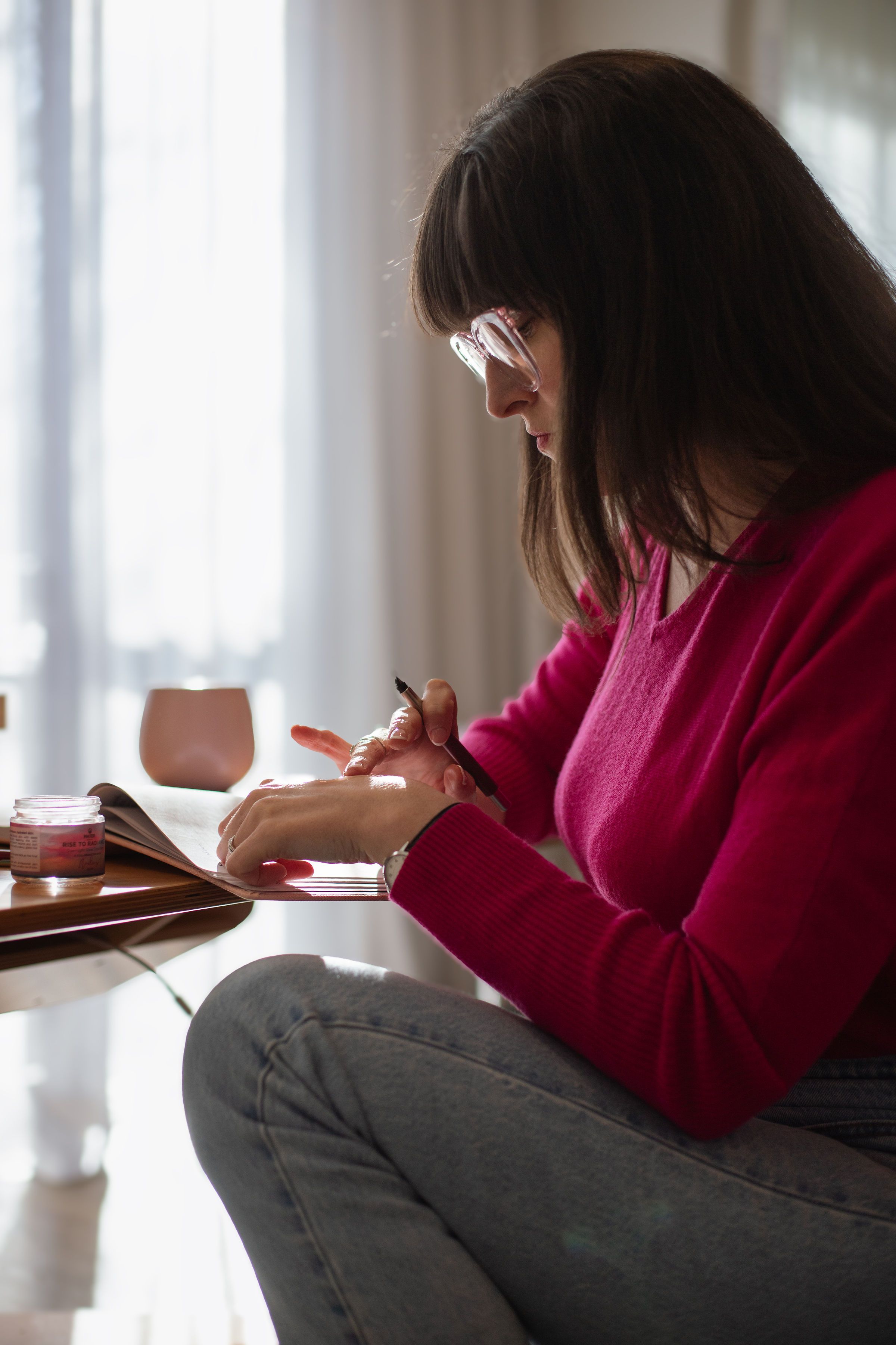 A woman with calm, healthy-looking skin in soft light