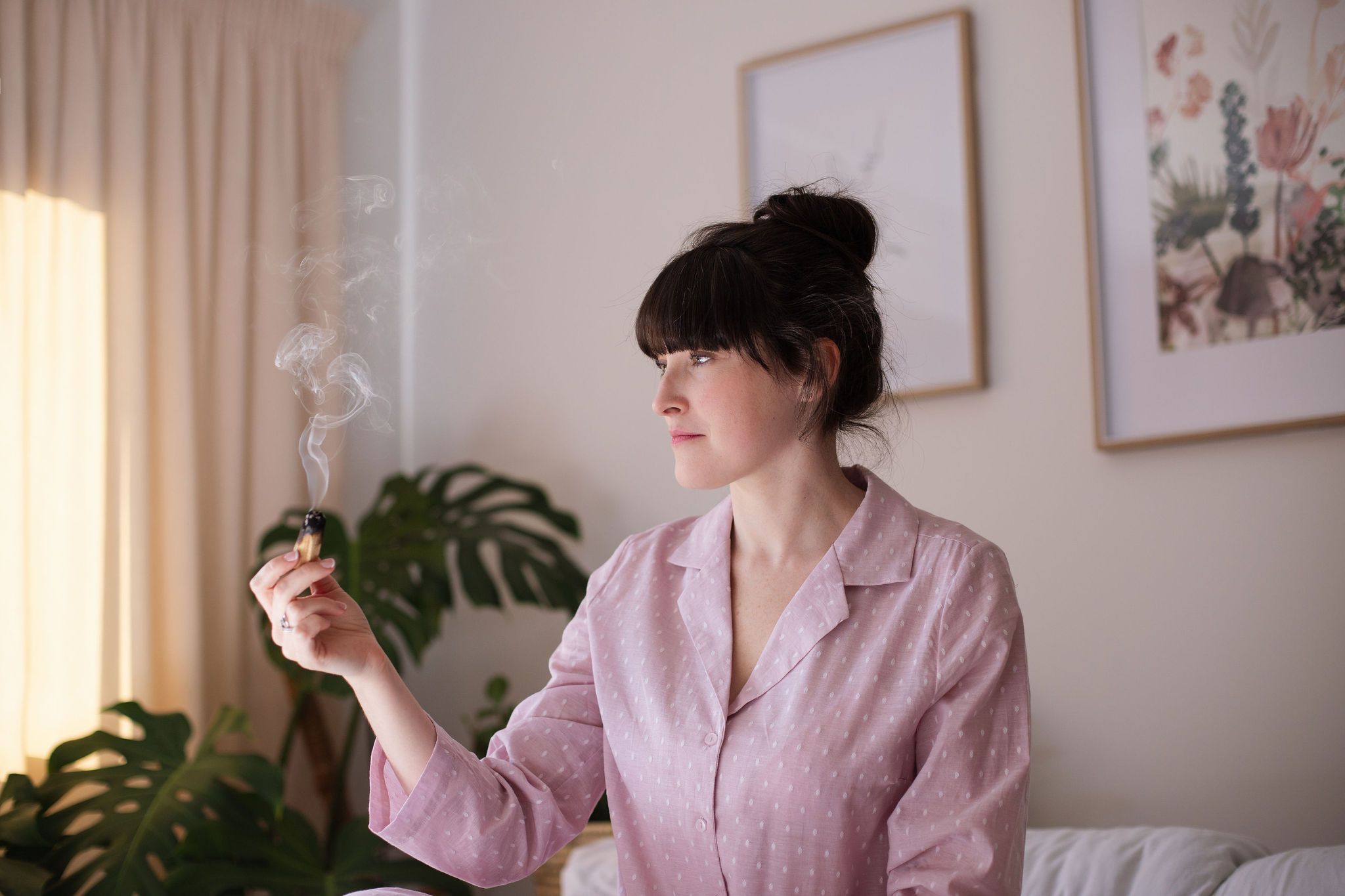 A woman listening to headphones, resting calmly in soft natural light.